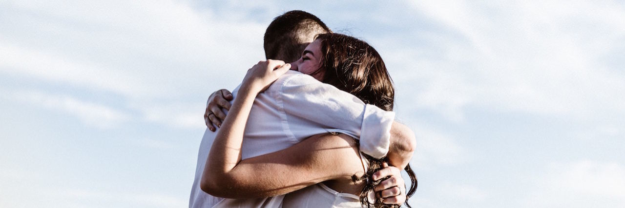 How to Support a Significant Other With Anxiety and Depression A couple hugging with the sky in the background