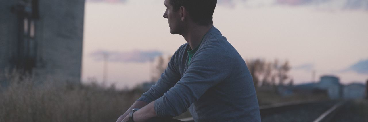 When Your OCD Makes You Obsessed With 'Karma' photo of young man sitting on train tracks