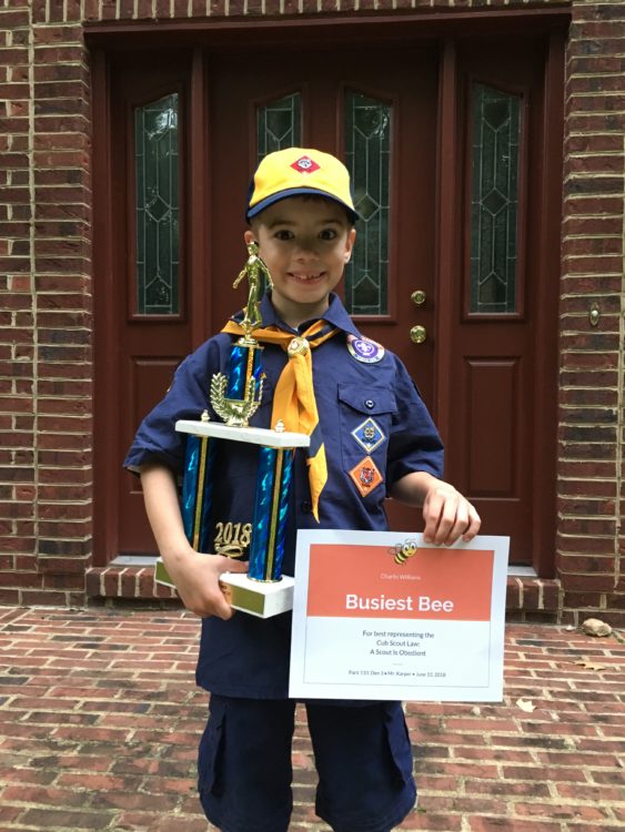 Boy posing with Scout trophy and Scout certificate