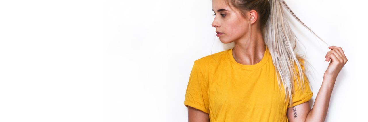 Mania and Denying My Bipolar Disorder in Hospital photo of young woman against white wall