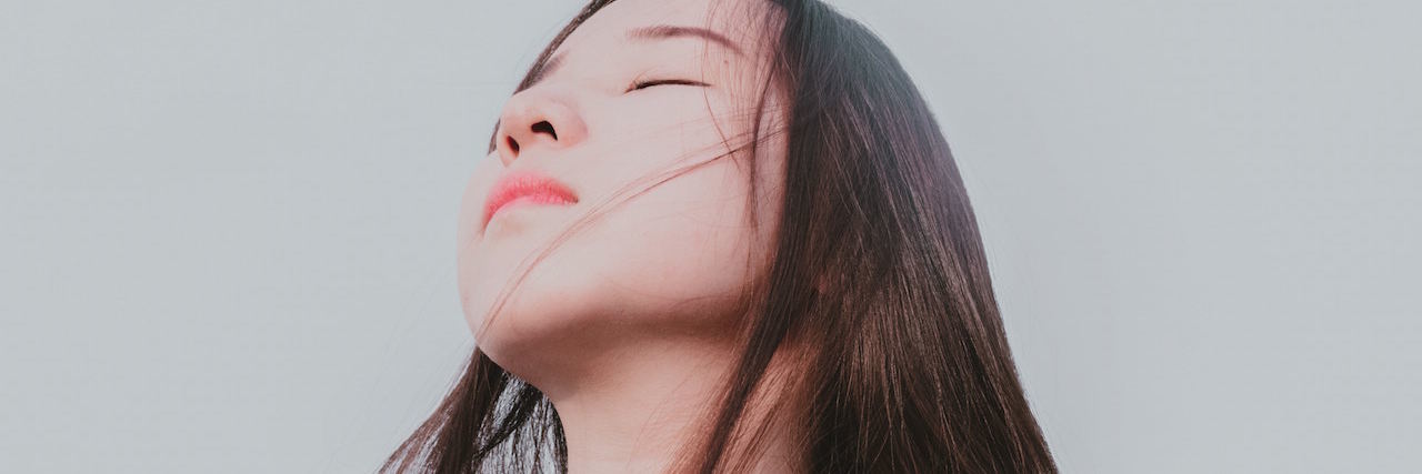 How Borderline Makes Me 'Addicted' to People A woman looking up in front of a grew sky