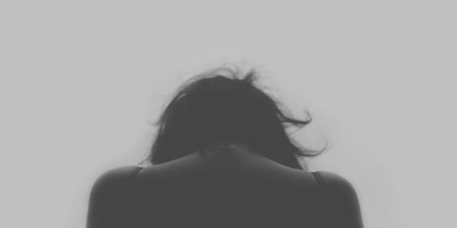 photo of the back of a woman, with her head looking down