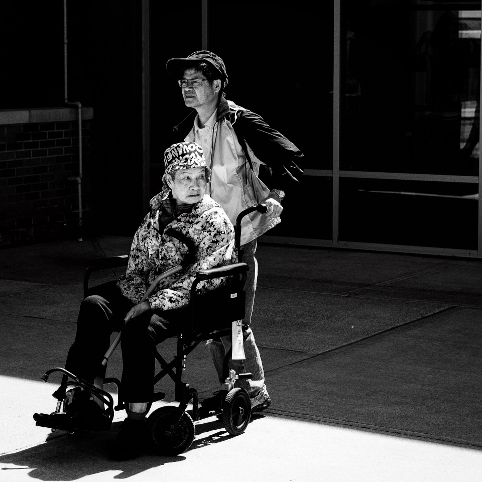 Man pushing an older man's wheelchair.