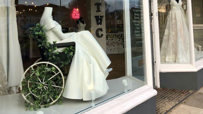 Mannequin in a wheelchair wearing a bridal gown.