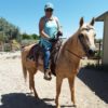 Cazandra riding a tan and cream horse.