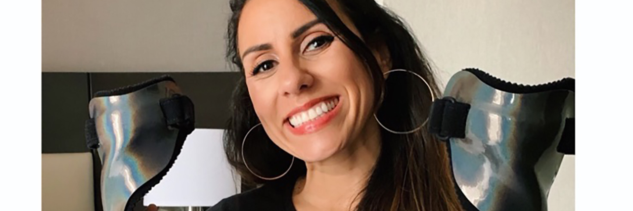 5 Necessary Evils When You Have a Disability Lainie smiling and holding up her leg braces.