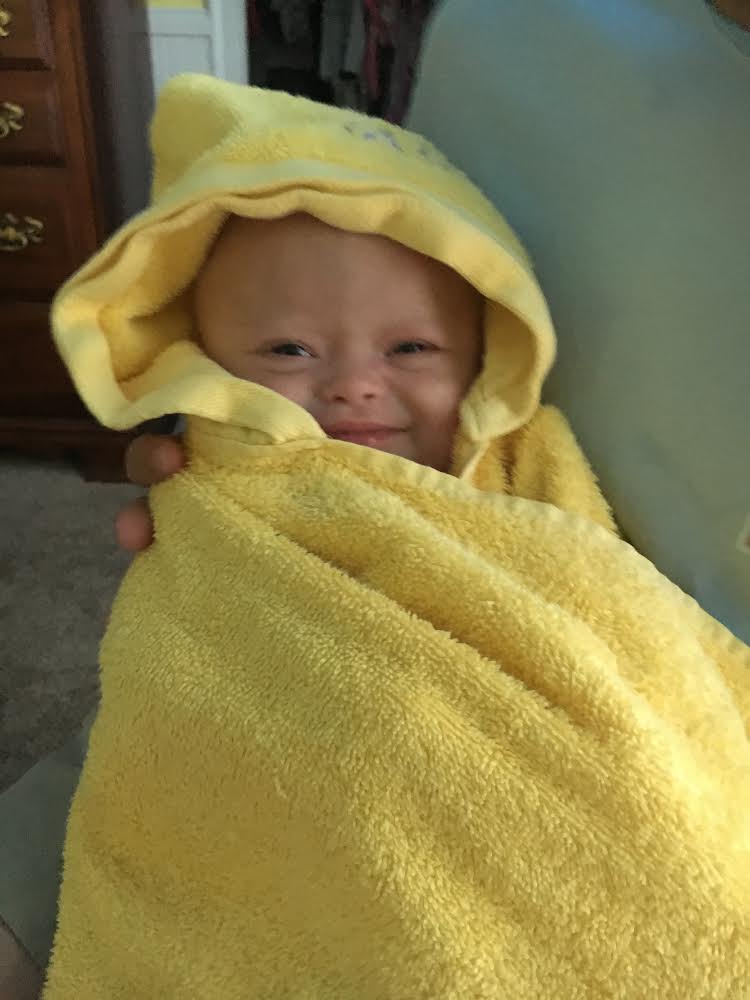 Baby Alice wrapped in a yellow towel.