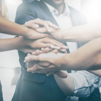 Group of 8 hands stacked together of young businessmen and women