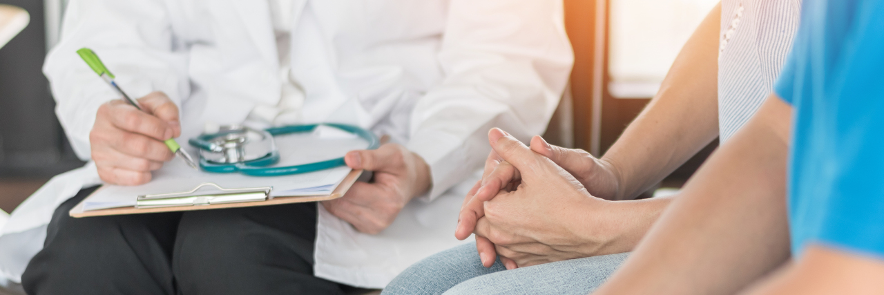 Going to Doctor's Appointments for Your Medically Complex Child doctor sitting next to two people with their hands crossed in their lap