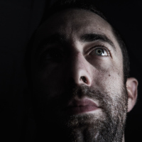 A dark portrait of a man looking up