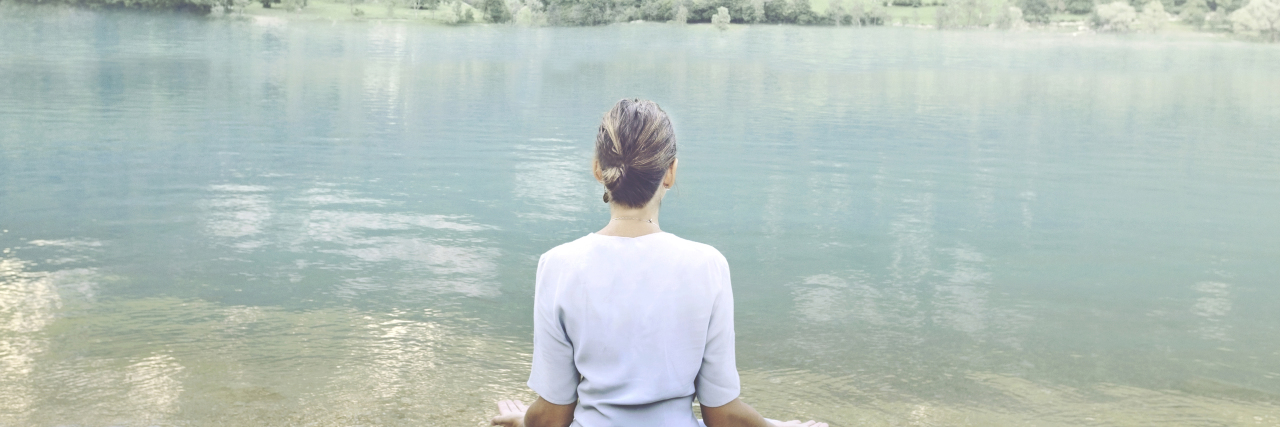 How Mindfulness Helps With the Challenges of Having Autism Woman doing yoga in front of a spectacular mountain lake.