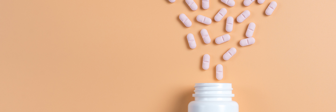Positive Effects of Taking an SSRI for Anxiety and Medication Pink pills, tablets and white bottle on yellow background.
