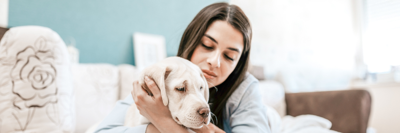 Changing My Career Because of Fibromyalgia Woman hugging her dog on the sofa.