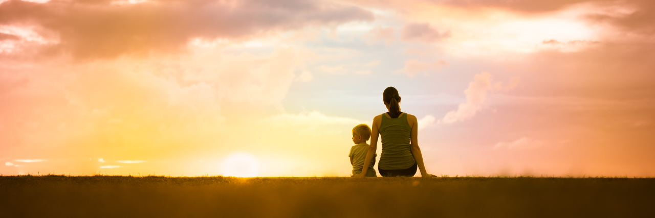Parenting a Child With an Invisible Illness: What It Feels Like Mother and son sitting together watching the sunset.