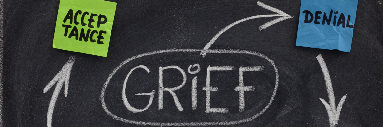 the 5 stages of grief (denial, anger, bargaining, depression, acceptance) written on a chalkboard