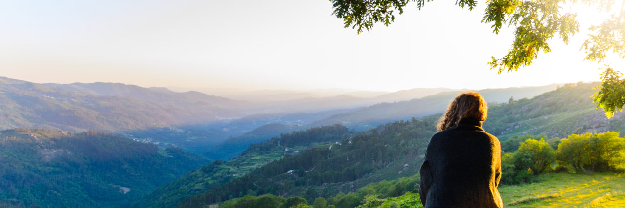 Coping Strategies After Losing a Child view of woman watching sunset in the mountains