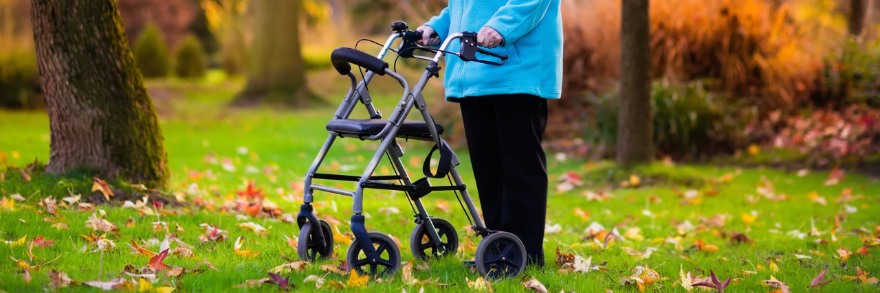 Woman using a walker in the grass.