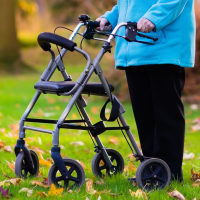 Woman using a walker in the grass.