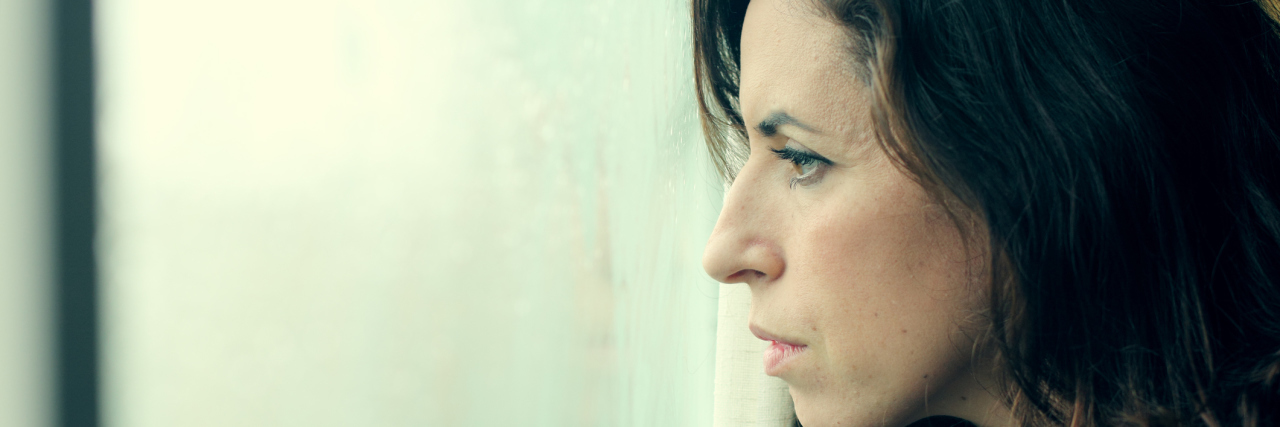 Low Self Esteem With Borderline Personality Disorder A woman stands and intensely stares out of a window.