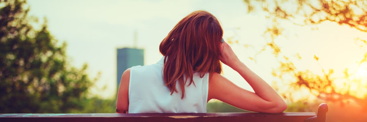 woman sitting on a bench during sunset