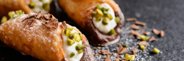 Traditional Sicilian cannoli stuffed with ricotta and pistachios.
