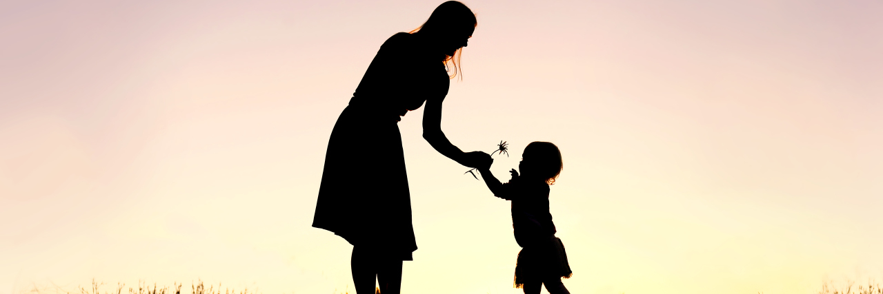 silhouette of a mom giving a little girl a flower