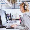 Woman wearing headphones working at computer.