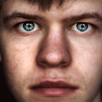 Close up of a young man with piercing blue eyes