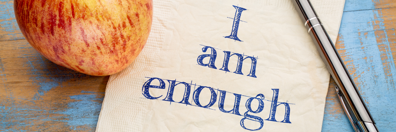I am enough positive affirmation - handwriting on a paper with a fresh apple nearby.