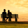 Man and woman sitting on bench near a bike