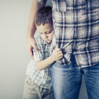 son hugging his dad's waist, father holding his son's shoulder