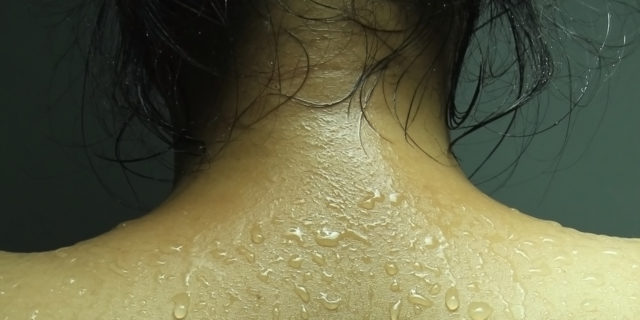 photo of a woman's back with beads of sweat visible