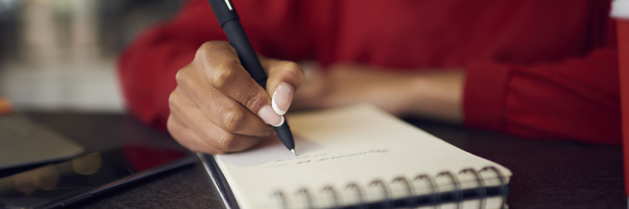 Using Lists to Improve Executive Functioning Woman writing in notebook.