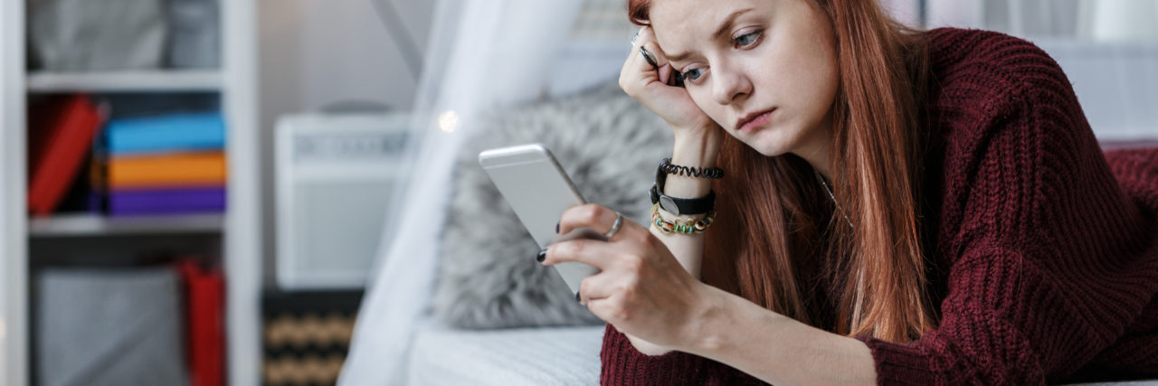 Learning to Manage Plans When You're Chronically Sick young woman on the phone laying on her bed