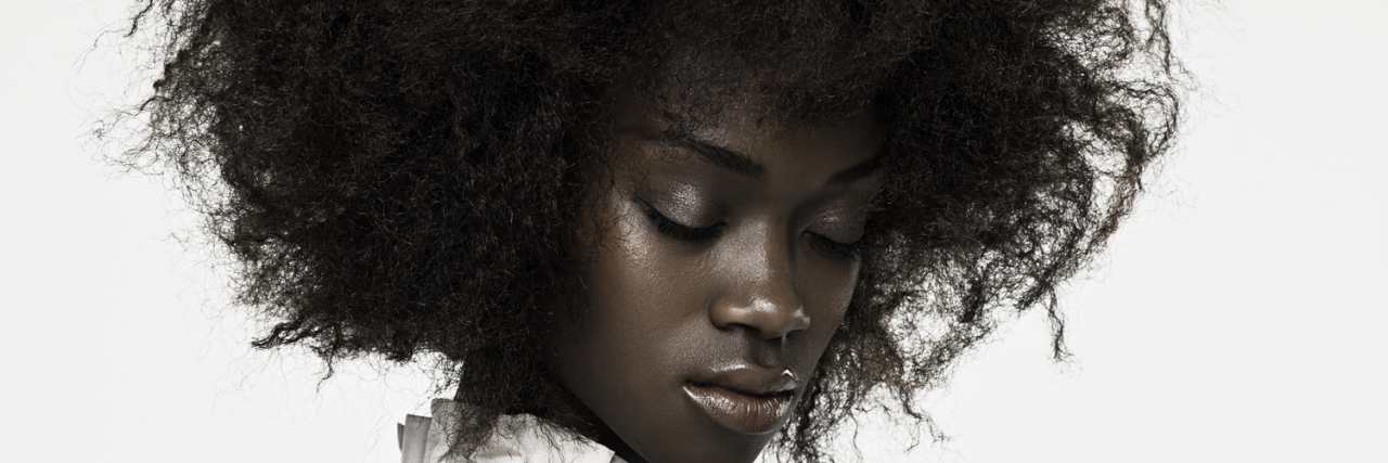 How to Help a Friend After a Death A woman stands alone, looking down at the ground.