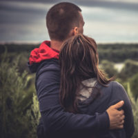Young couple embracing in a field.