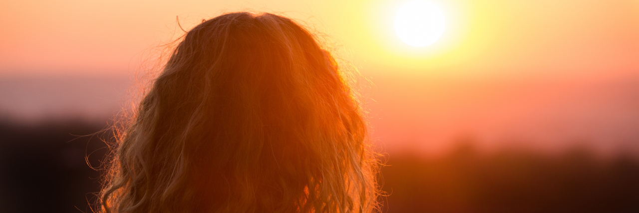 A Thank You to the Stigma Surrounding Mental Health a woman is looking at the sunset