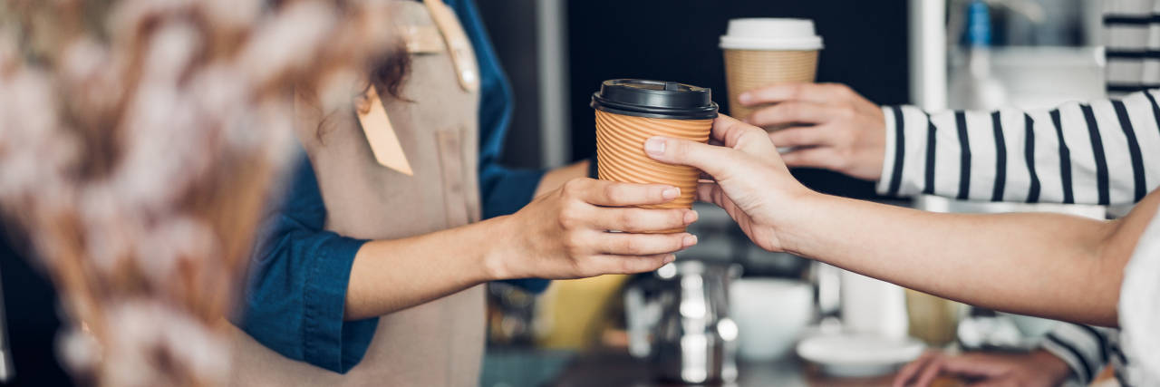 Companies That Employ People With Down Syndrome a barista serving a coffee cup to a customer