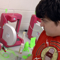 Henry using a 3D printer at YouthQuest.