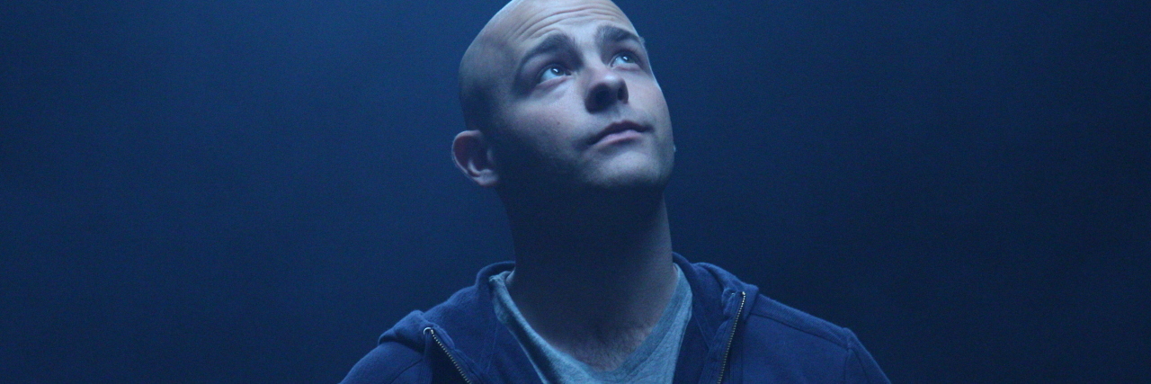 photo of filmmaker Nick Cavalier looking up in blue light