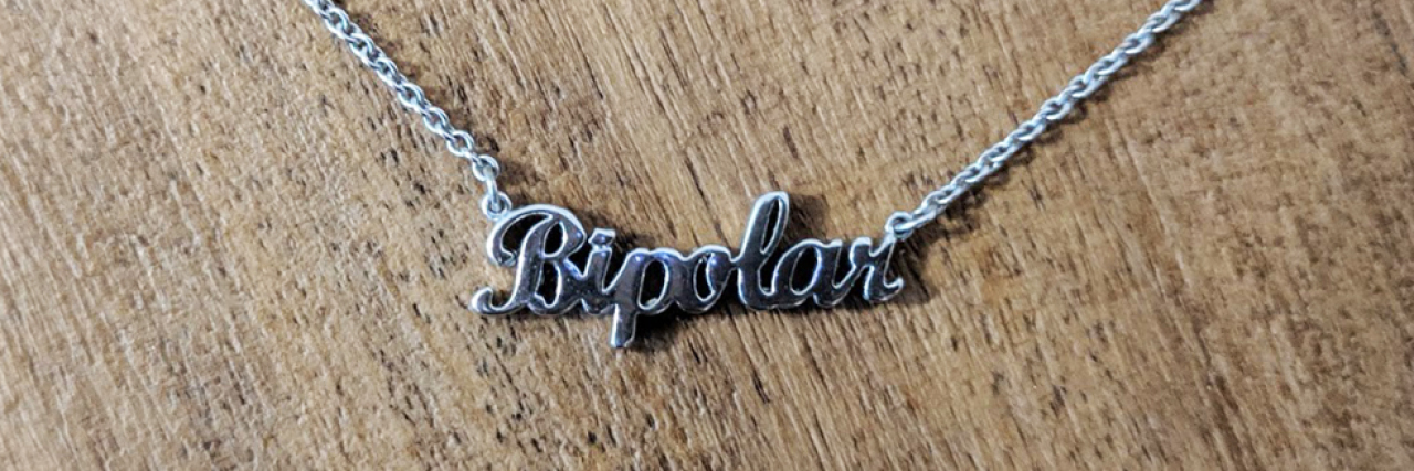 photo of silver nameplate necklace of word 'bipolar'