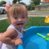 little girl with Down syndrome playing at a water table