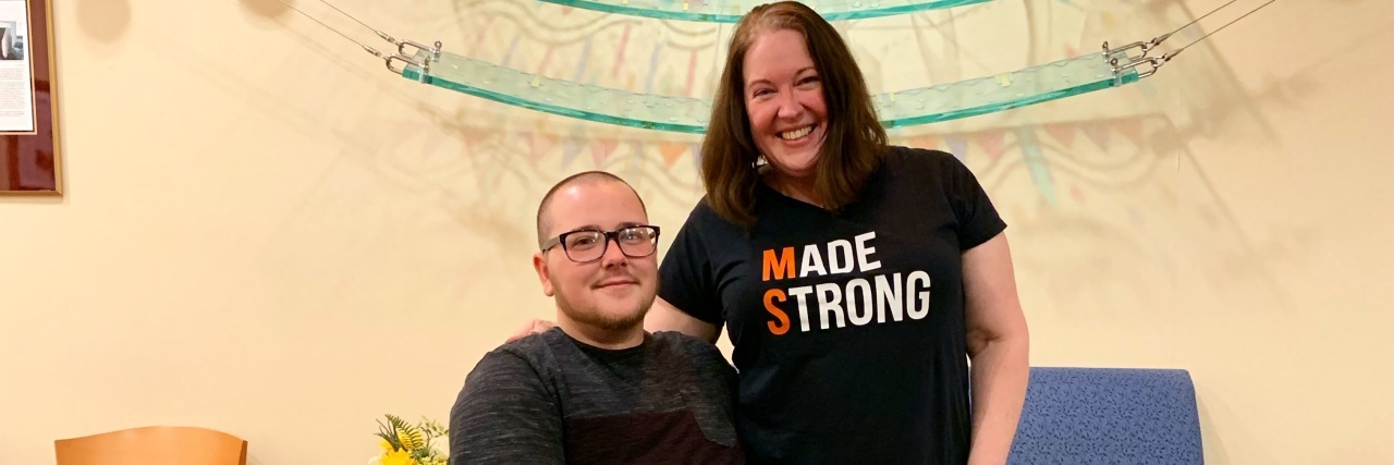 Talking to Your Kids About Your Multiple Sclerosis Jordyn with his Mom. She is wearing a shirt that says Made Strong with the M and the S in orange to support MS.