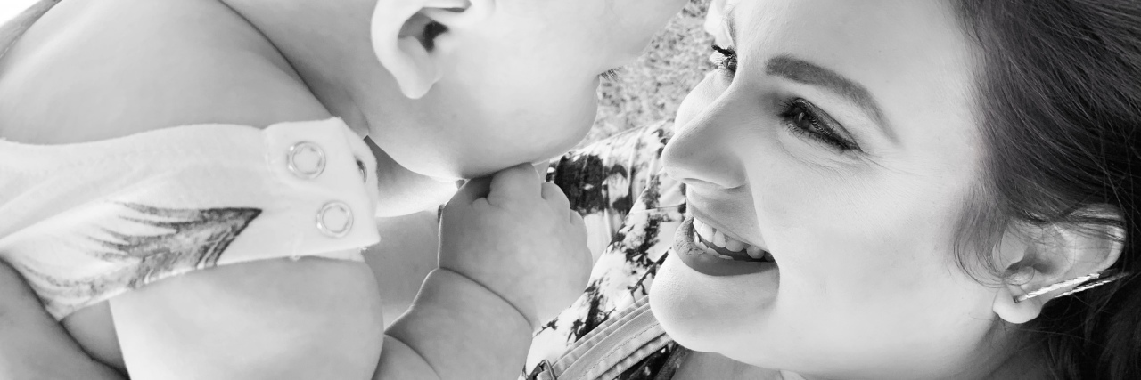 Why a Harmless Run to Target With My Children Triggered My PTSD black and white photo of woman holding baby looking into their eyes