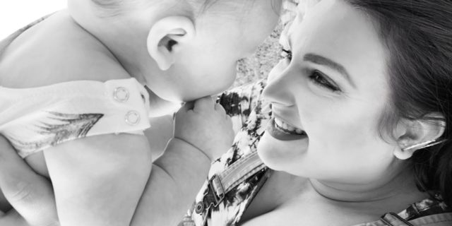 Why a Harmless Run to Target With My Children Triggered My PTSD black and white photo of woman holding baby looking into their eyes