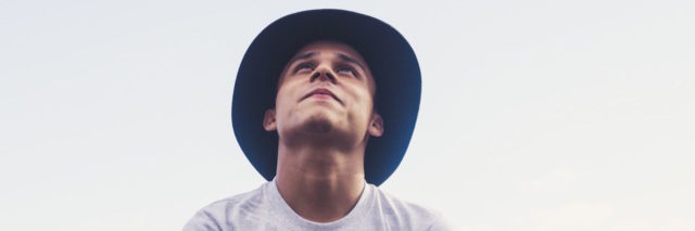 A man wearing a hat looking up