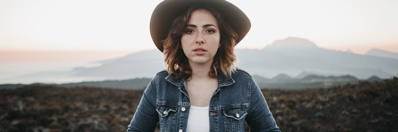 A Letter to America: Mental Illness Not the Cause of Mass Shootings A woman wearing a hat standing outdoors in rocky terrain