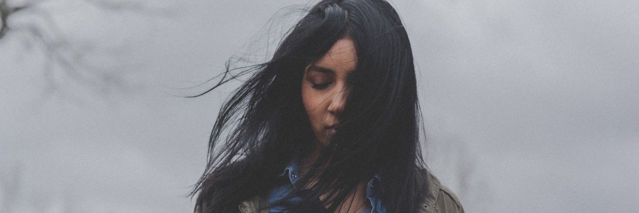 The Impact of Brain Fog on Emotions and Feelings woman in jacket looking down at the ground