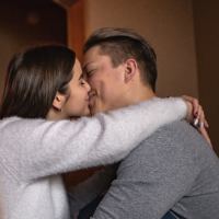 photo of young man and woman kissing on bed