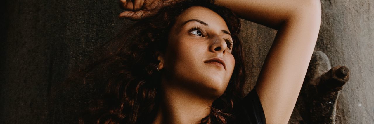 Chronic Pain: Can't to Cope With Other People's Problems photo of young woman lying on floor looking away with arm raised over her head